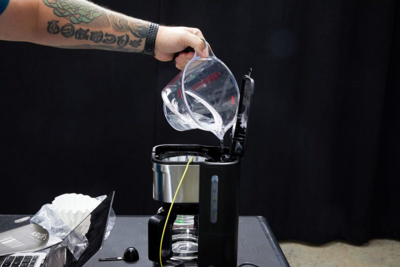 Đổ nước vào bình chứa máy pha cà phê